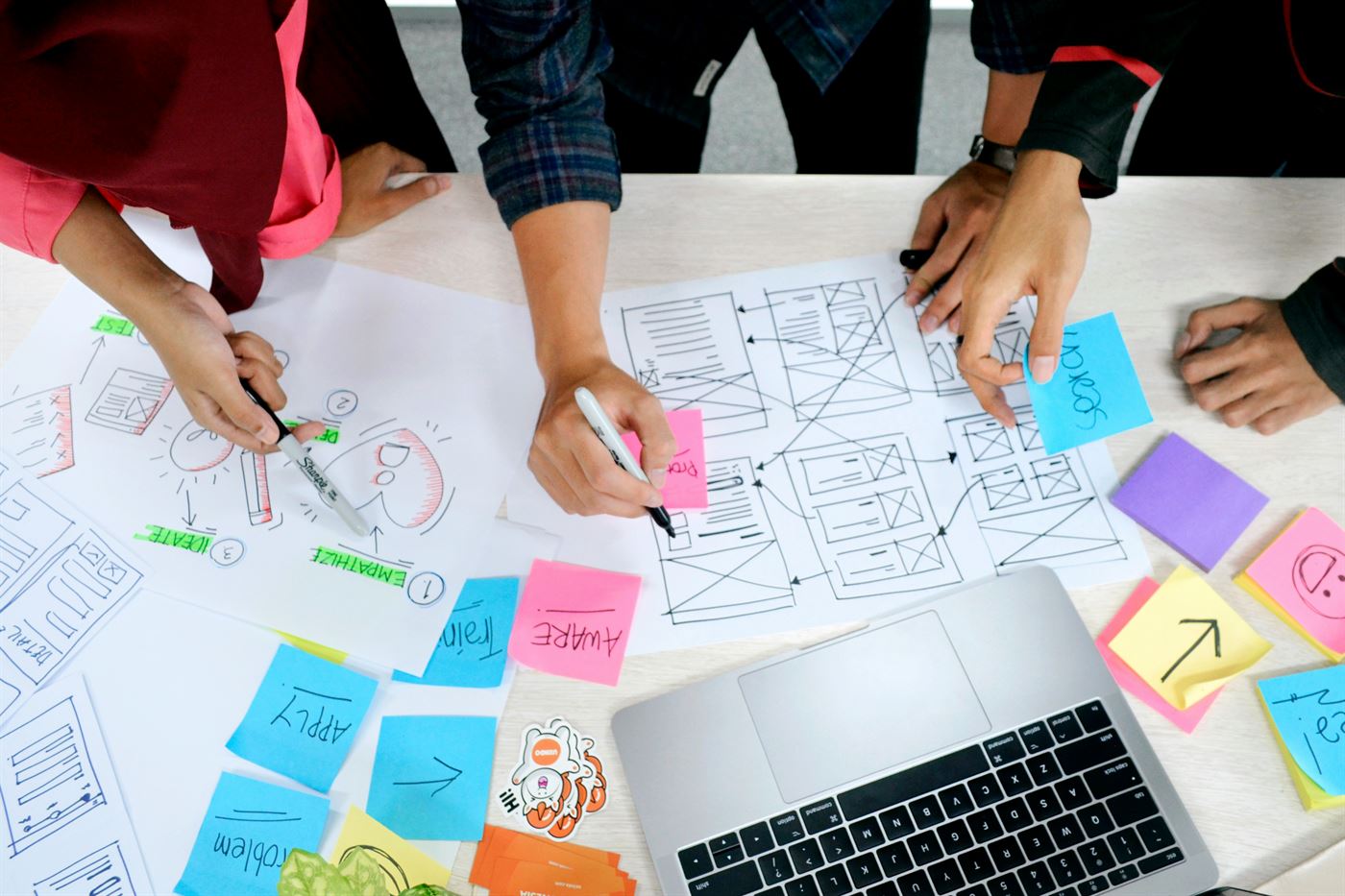 Team skizziert Wireframes und Klebezettel auf einem Tisch